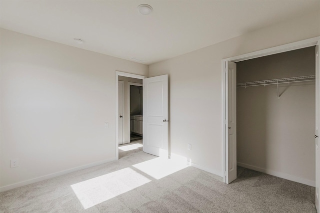 unfurnished bedroom with a closet and light carpet