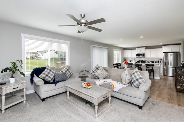 living room featuring ceiling fan and hardwood / wood-style floors