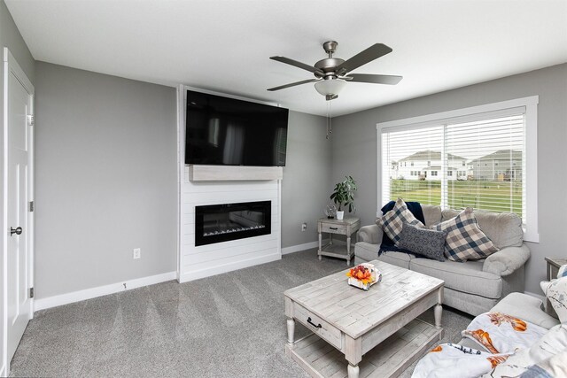 living room featuring carpet, ceiling fan, and a large fireplace