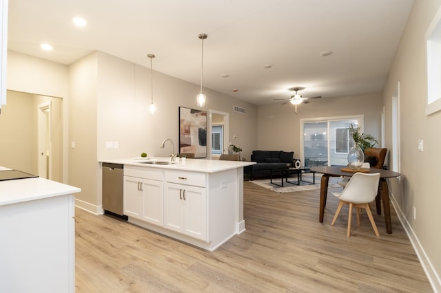 kitchen featuring dishwasher, sink, pendant lighting, white cabinets, and light wood-type flooring