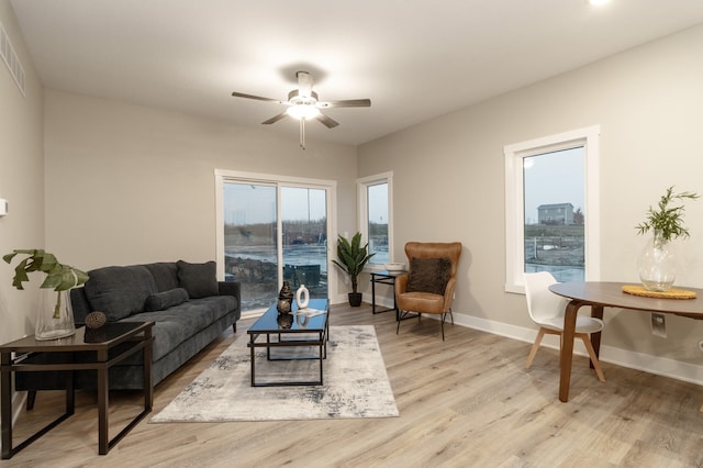 living room with light hardwood / wood-style flooring and ceiling fan