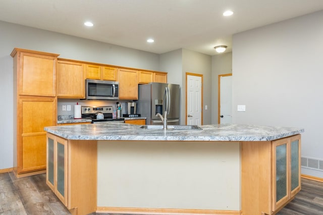 kitchen featuring a center island with sink, sink, stainless steel appliances, and hardwood / wood-style flooring