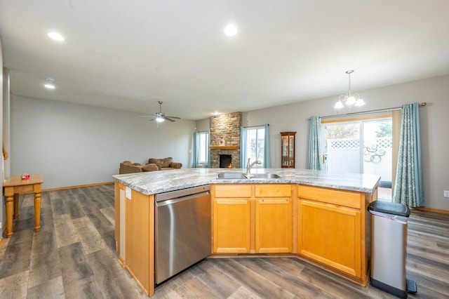 kitchen featuring an island with sink, stainless steel dishwasher, dark wood-type flooring, and sink