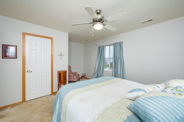 carpeted bedroom featuring a textured ceiling and ceiling fan