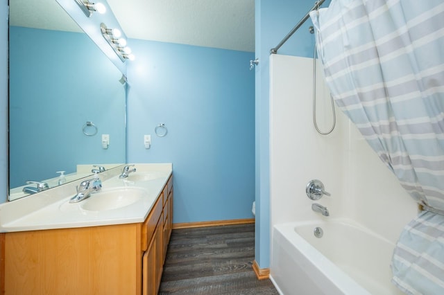 bathroom with hardwood / wood-style floors, vanity, shower / bathtub combination with curtain, and a textured ceiling