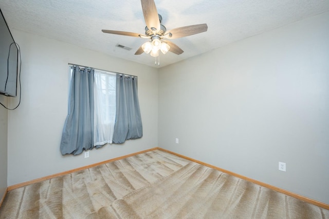 carpeted spare room with ceiling fan and a textured ceiling