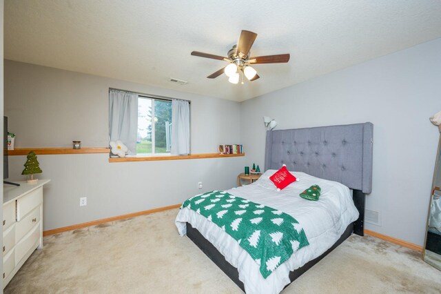 bedroom with ceiling fan and light carpet