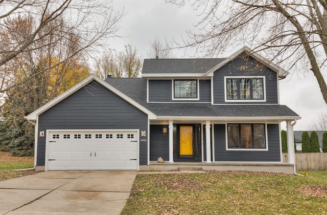 view of front of home featuring a porch, a garage, and a front yard