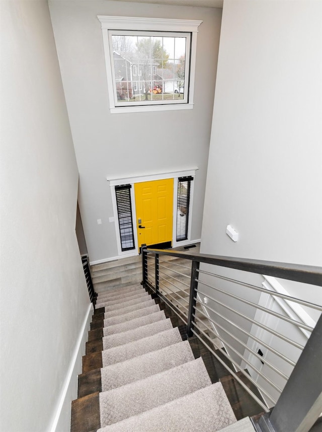 6562 Center St, West Des Moines, IA 50266 - stairs with a towering ceiling, wood finished floors, and baseboards