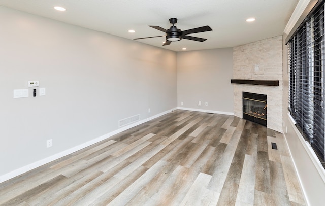 unfurnished living room with a fireplace, light hardwood / wood-style floors, and ceiling fan