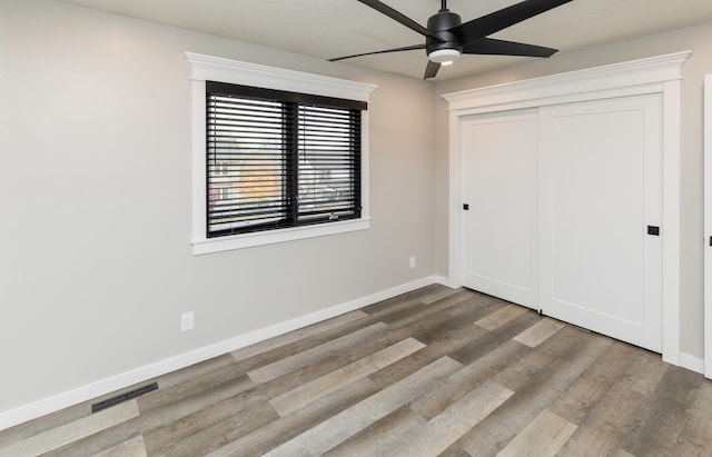 unfurnished bedroom with hardwood / wood-style floors, a closet, and ceiling fan