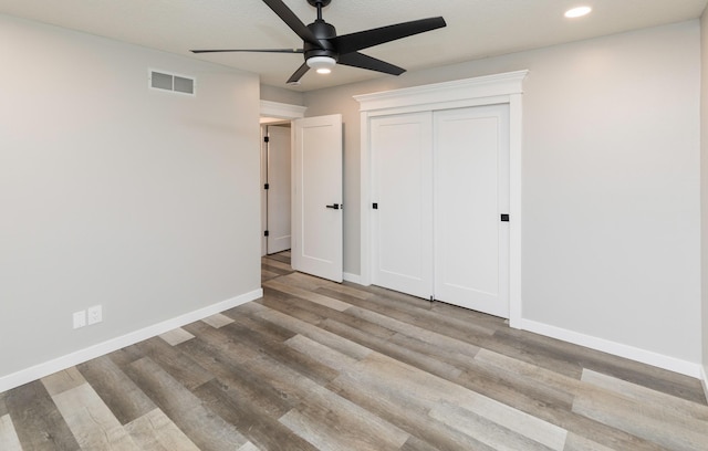 6562 Center St, West Des Moines, IA 50266 - unfurnished bedroom featuring recessed lighting, baseboards, wood finished floors, a ceiling fan, and a closet