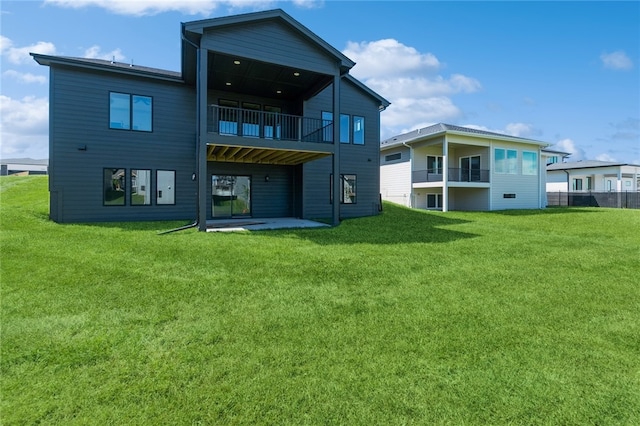 back of property featuring a yard, a patio area, and a balcony