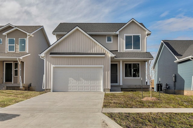 view of front of home with a garage, central AC unit, and a front yard