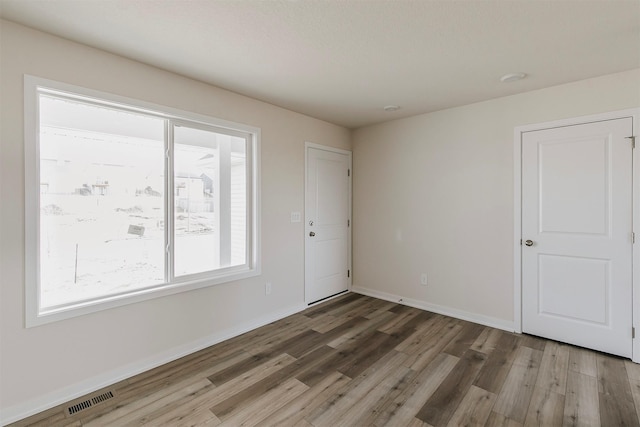 unfurnished room with hardwood / wood-style flooring