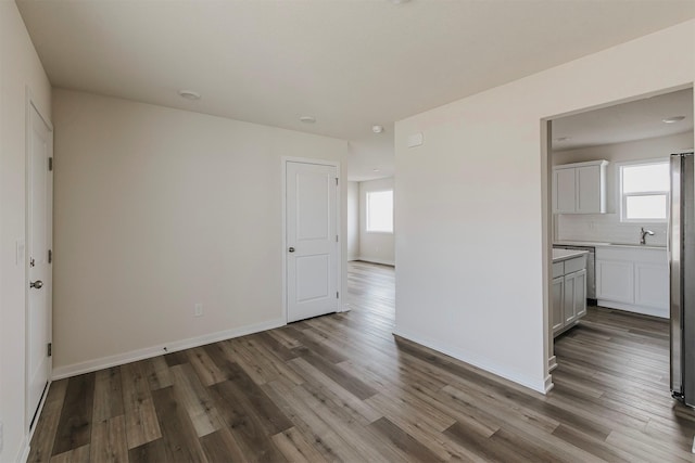 spare room with sink and hardwood / wood-style floors