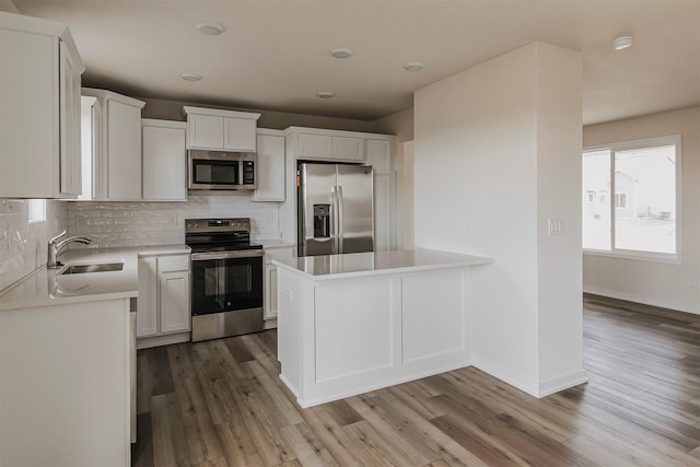 kitchen featuring stainless steel appliances, tasteful backsplash, sink, and white cabinets