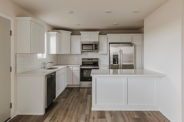 kitchen with tasteful backsplash, appliances with stainless steel finishes, sink, and white cabinets