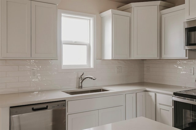 kitchen with white cabinetry, sink, backsplash, and appliances with stainless steel finishes