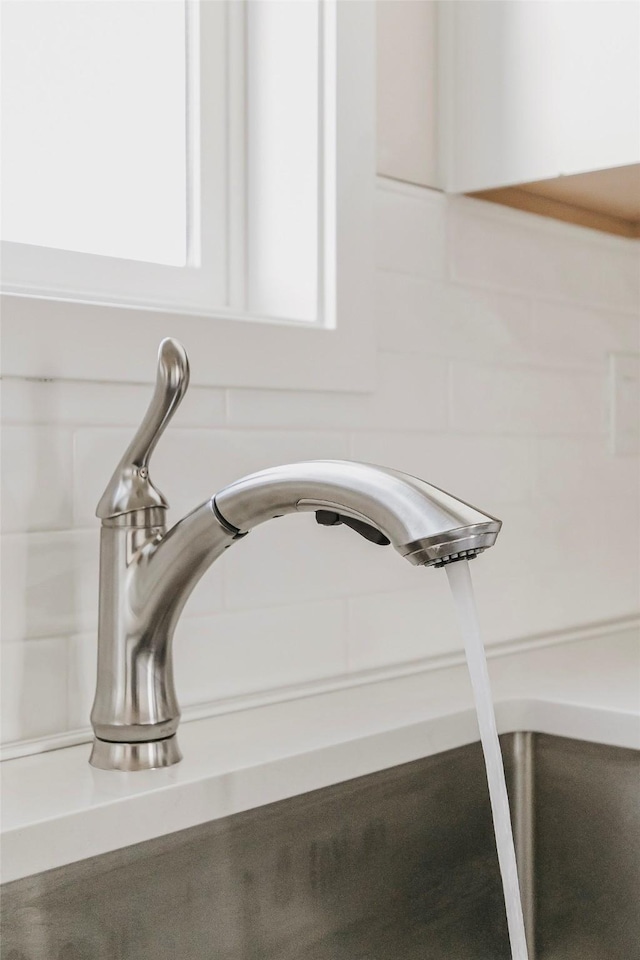 interior details featuring white cabinetry and sink