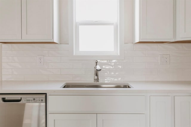 kitchen with sink, backsplash, stainless steel dishwasher, and white cabinets