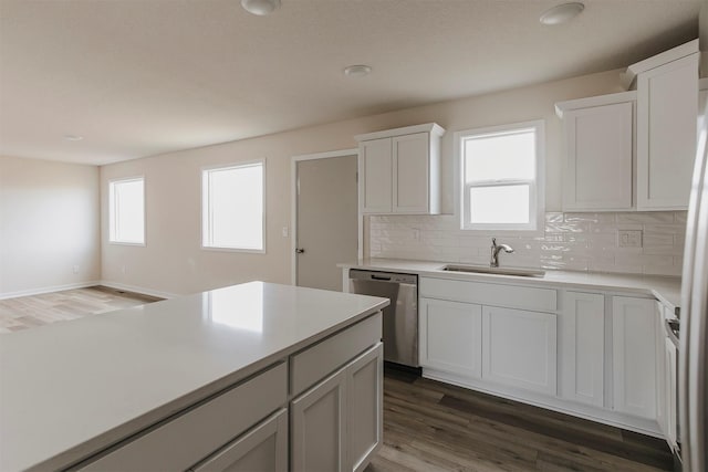 kitchen featuring sink, white cabinetry, tasteful backsplash, a healthy amount of sunlight, and stainless steel dishwasher