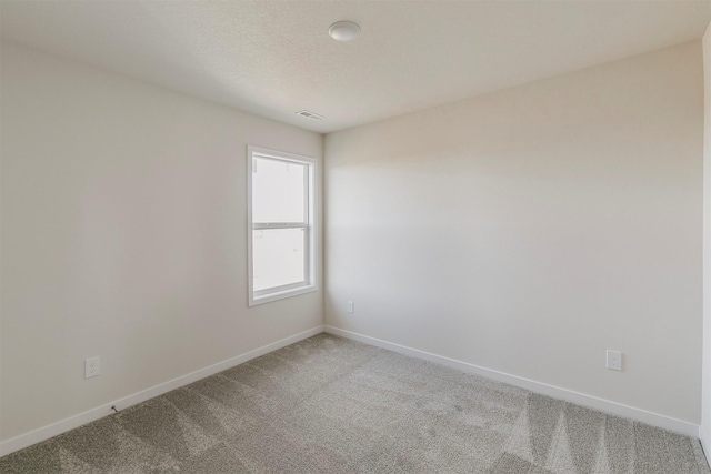 carpeted spare room with a textured ceiling