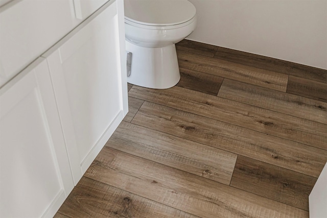 details with hardwood / wood-style flooring and toilet