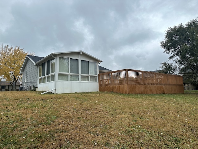 view of home's exterior featuring a yard and a sunroom