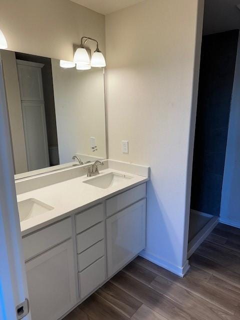 bathroom featuring hardwood / wood-style flooring, vanity, and a shower