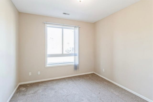 empty room with carpet floors and a wealth of natural light