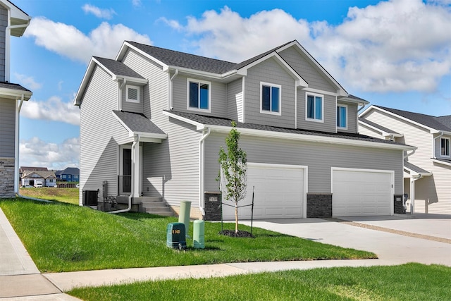 5130 Ella Ivy Ct, Van Meter, IA 50261 - craftsman-style house featuring an attached garage, a front lawn, driveway, central AC, and roof with shingles