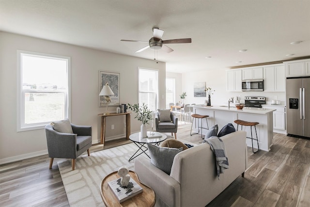 5130 Ella Ivy Ct, Van Meter, IA 50261 - living area with plenty of natural light, light wood finished floors, ceiling fan, and recessed lighting