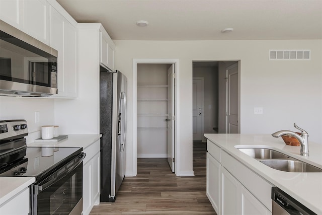 5130 Ella Ivy Ct, Van Meter, IA 50261 - kitchen featuring stainless steel appliances, a sink, light wood-style flooring, and light countertops