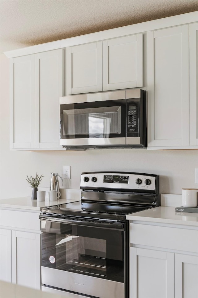 5130 Ella Ivy Ct, Van Meter, IA 50261 - kitchen featuring stainless steel appliances, white cabinetry, and light countertops