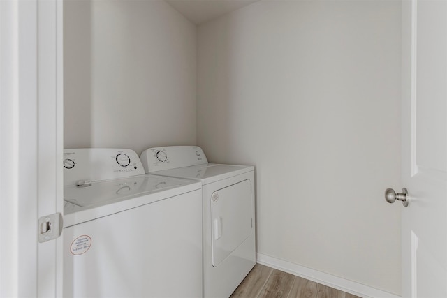 5130 Ella Ivy Ct, Van Meter, IA 50261 - laundry area featuring washing machine and dryer, light wood-style flooring, and baseboards