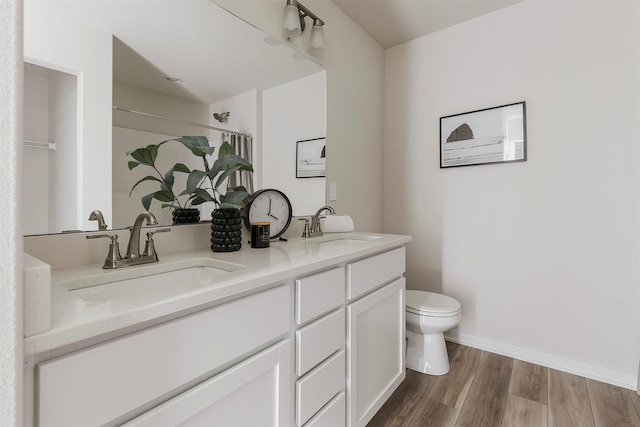 5130 Ella Ivy Ct, Van Meter, IA 50261 - full bathroom with toilet, double vanity, wood finished floors, a shower with shower curtain, and baseboards