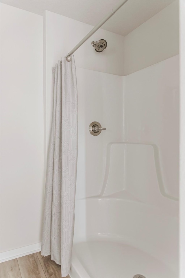 5130 Ella Ivy Ct, Van Meter, IA 50261 - bathroom featuring a shower with shower curtain and wood finished floors