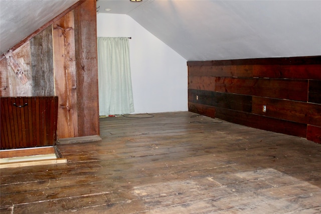 additional living space with vaulted ceiling and dark hardwood / wood-style floors