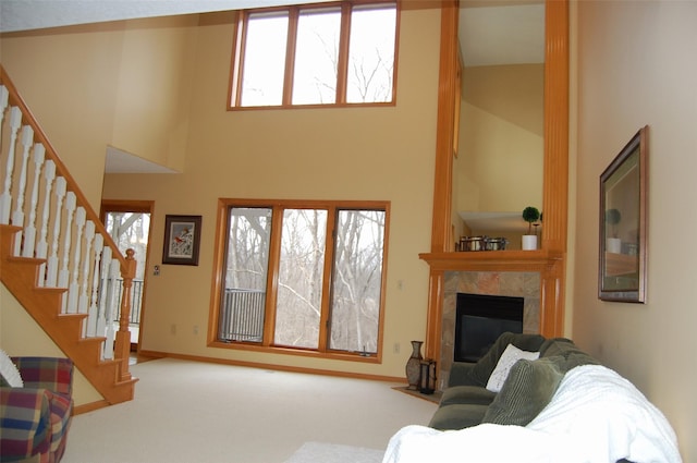 carpeted living room with a high ceiling and a fireplace