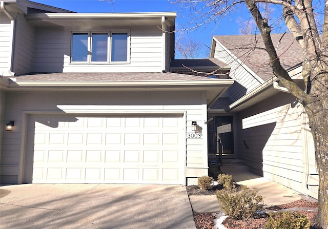 view of front of property with a garage, driveway, and a shingled roof