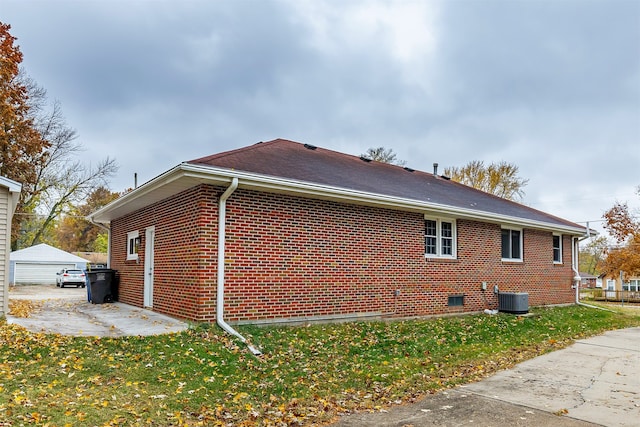 view of property exterior with central AC unit and a lawn