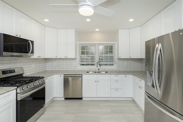 kitchen featuring stainless steel appliances, white cabinetry, and sink