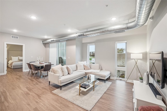 living room featuring recessed lighting, visible vents, baseboards, and wood finished floors