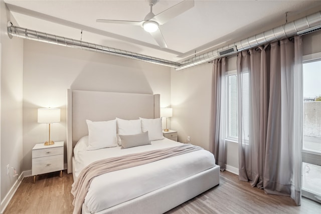 bedroom featuring light wood-type flooring, a ceiling fan, and baseboards