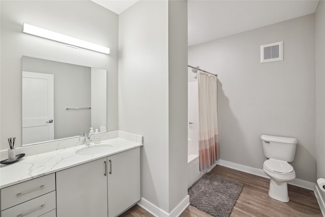 full bathroom featuring toilet, wood finished floors, vanity, visible vents, and shower / tub combo with curtain