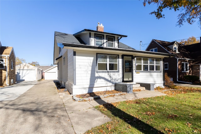 view of front of property featuring a front lawn, an outdoor structure, and a garage