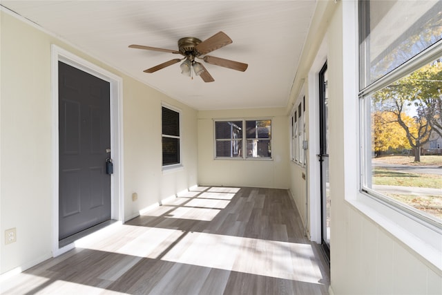 unfurnished sunroom featuring a wealth of natural light and ceiling fan