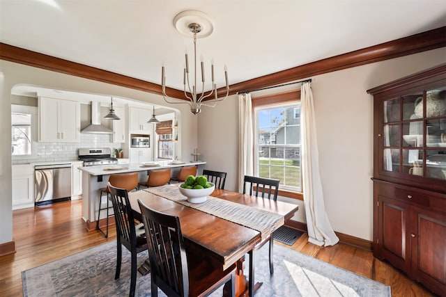 dining space featuring wood-type flooring and an inviting chandelier