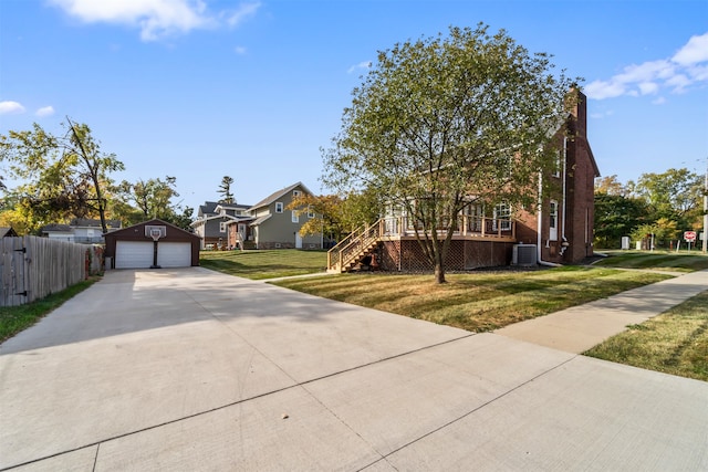 view of front facade with central air condition unit, a front yard, an outbuilding, a wooden deck, and a garage